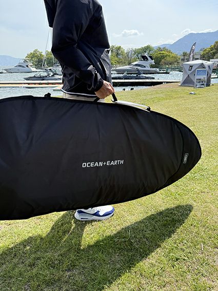 OCEAN&EARTHのボードバッグ　 COR_X FISH DAY COVER 5.4ftを実際に持っている様子